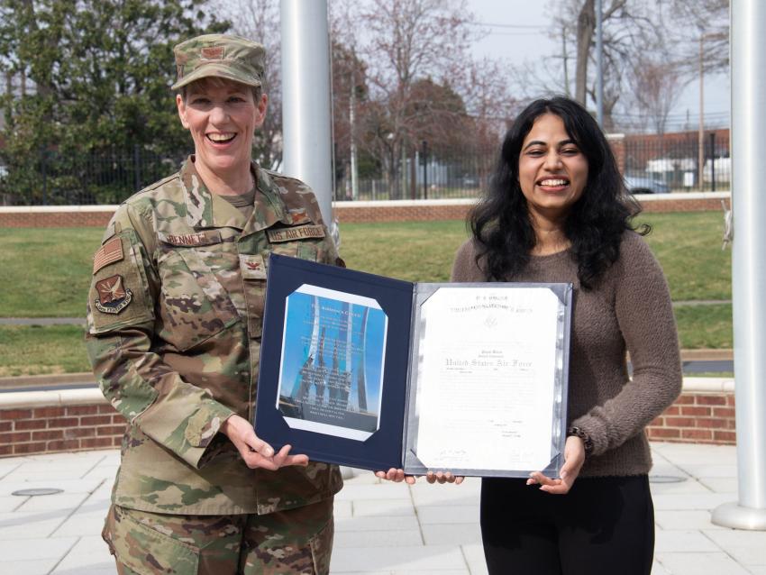 VCOM-Carolinas student holding her commissioning certificate with an Army member
