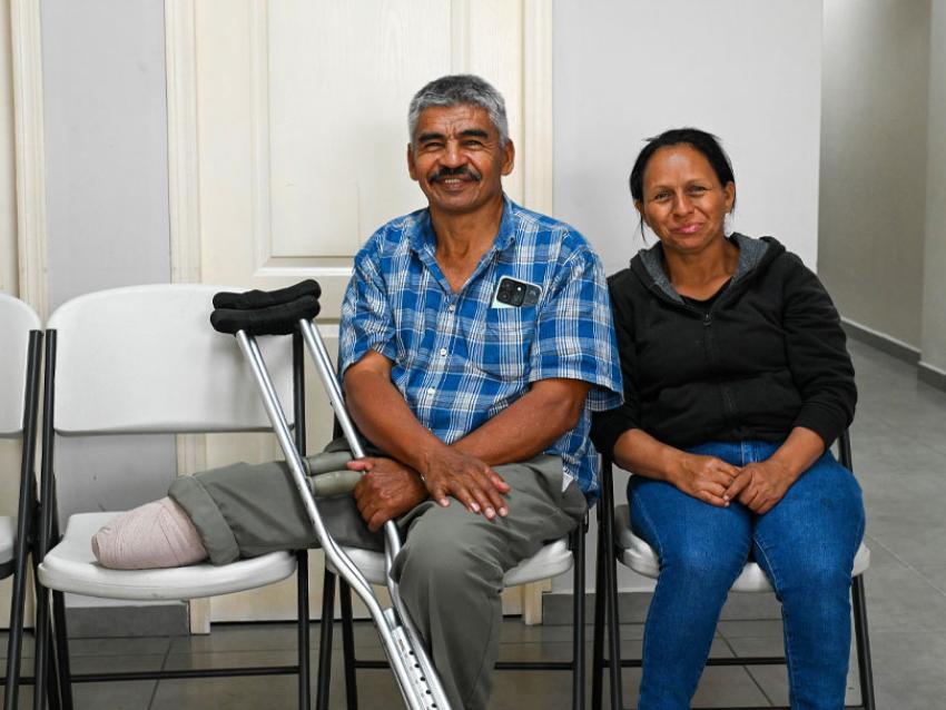 Man with amputated leg sitting with a woman smiling