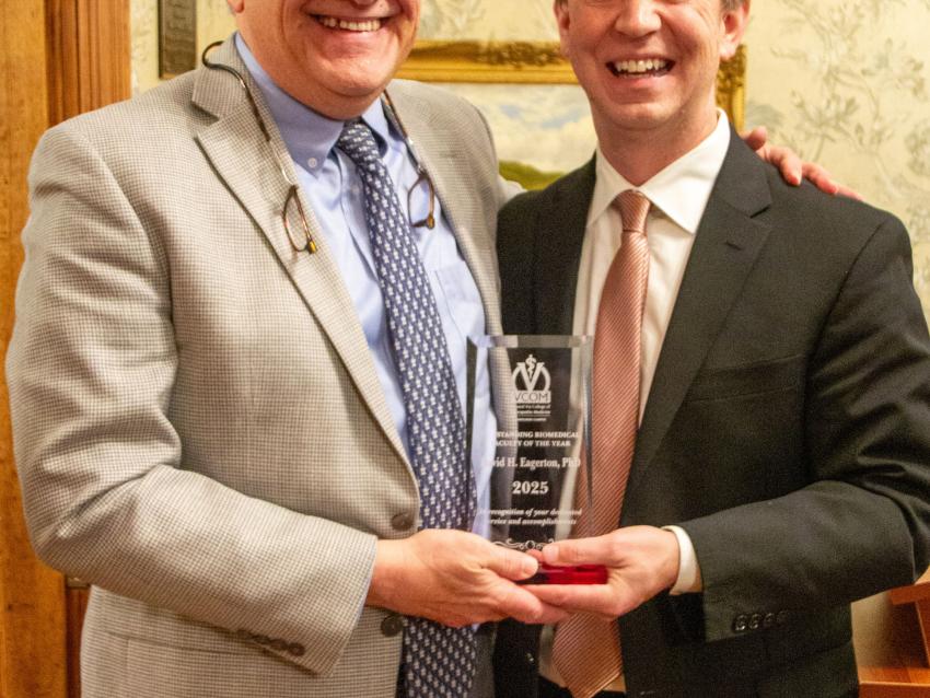 Dr Eagerton and Dr Cannon smiling while holding award