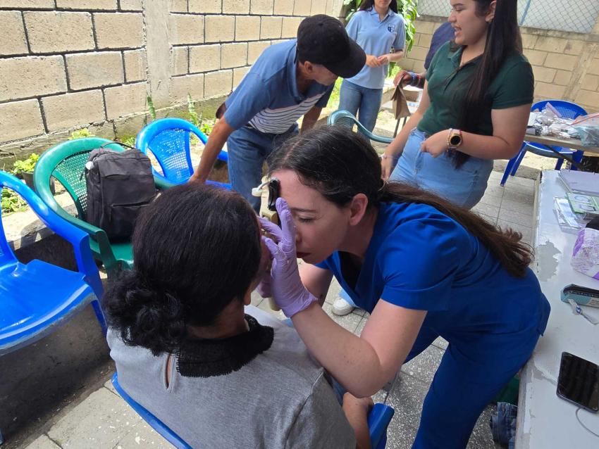 Student doctor examining a patient's eye