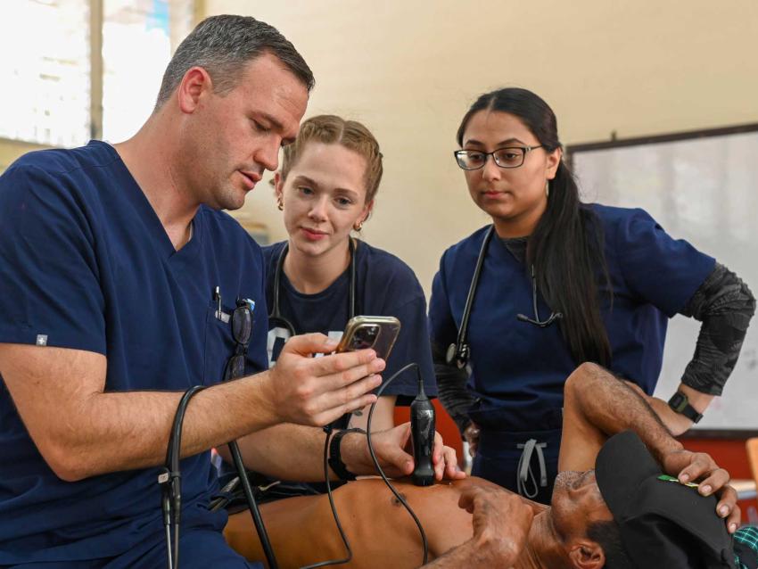 Jonas Rawlins, DO using an ultrasound with two VCOM medical students