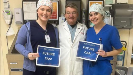Two CAA students with a doctor smiling