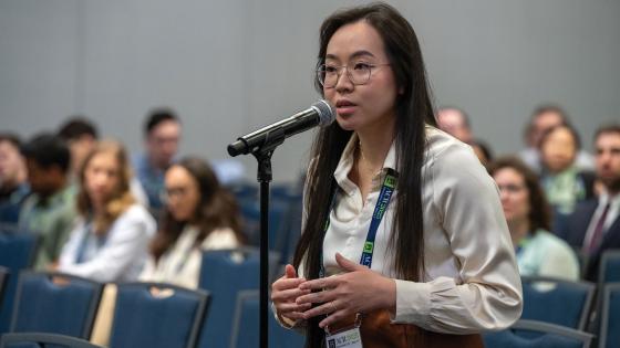 Annie Pham standing and speaking into a microphone