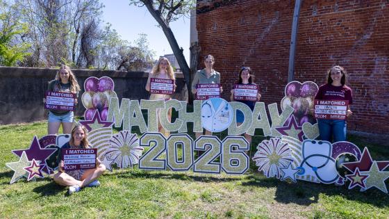 VCOM-Louisiana class of 2026 students outside holding their match day signs