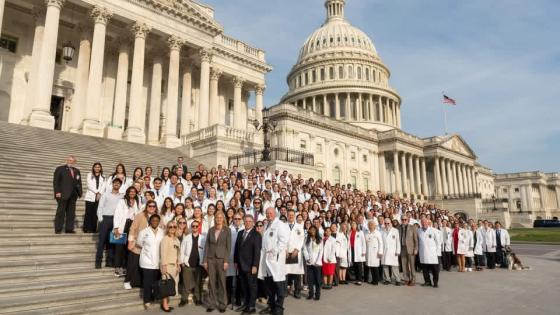 Large group of student doctors standing on the steps of the Capitol building
