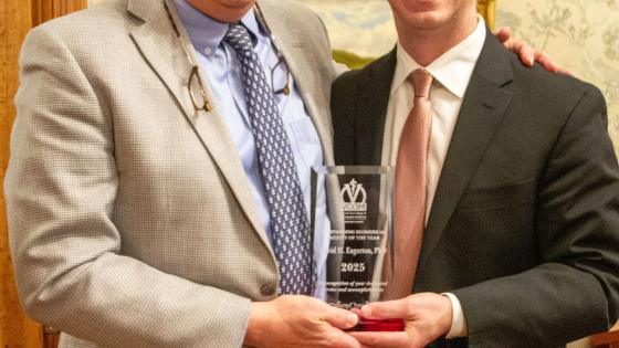Dr Eagerton and Dr Cannon smiling while holding award