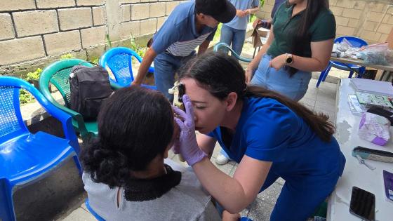 Student doctor examining a patient's eye